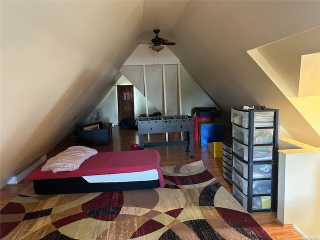 bedroom with ceiling fan, hardwood / wood-style floors, and vaulted ceiling