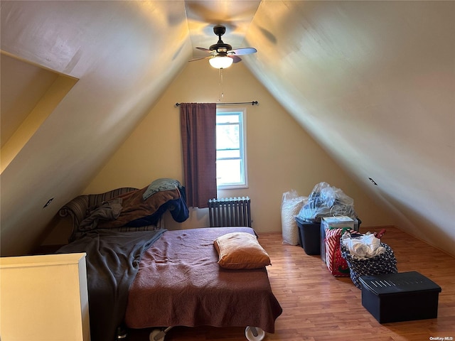 bedroom with hardwood / wood-style floors, radiator, lofted ceiling, and ceiling fan