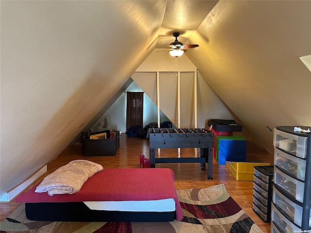 game room with hardwood / wood-style floors, ceiling fan, and vaulted ceiling