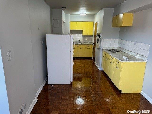 kitchen featuring dark parquet floors, white appliances, sink, and tasteful backsplash