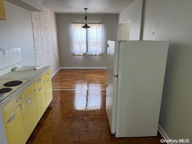 kitchen featuring decorative backsplash, dark parquet floors, white fridge, and hanging light fixtures