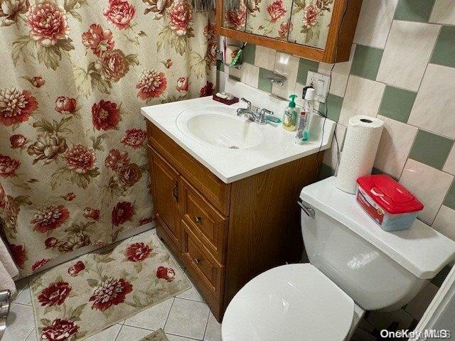 bathroom featuring tile patterned flooring, vanity, and toilet