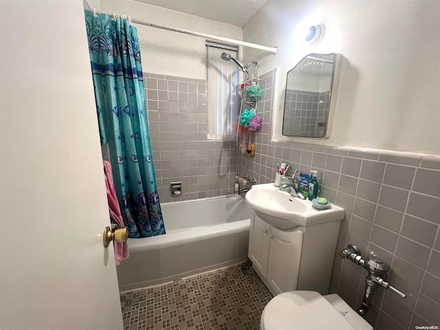 full bathroom with shower / bath combination with curtain, vanity, toilet, and tile walls