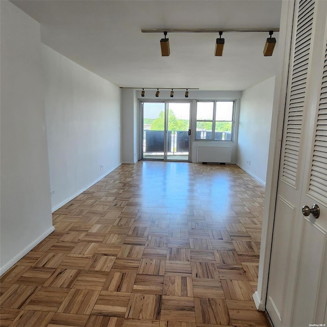 unfurnished room featuring light parquet floors and track lighting