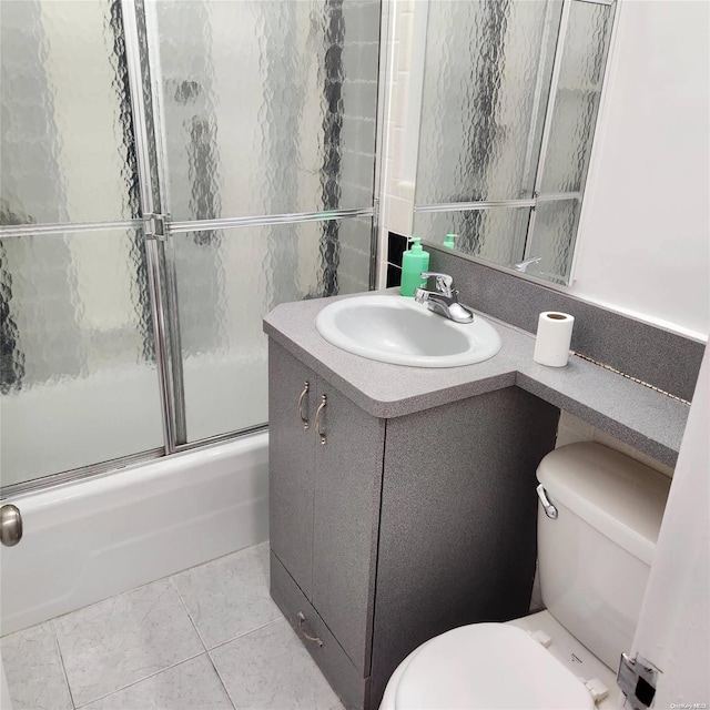 full bathroom with tile patterned flooring, vanity, toilet, and bath / shower combo with glass door