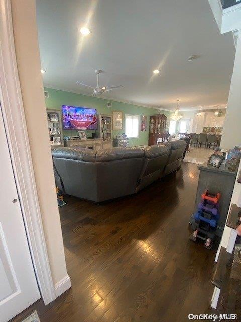 living room featuring ceiling fan and dark wood-type flooring