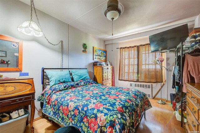 bedroom featuring radiator and light hardwood / wood-style flooring