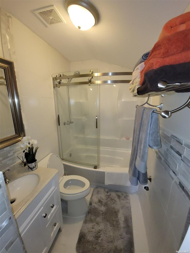 full bathroom featuring tile patterned flooring, enclosed tub / shower combo, lofted ceiling, toilet, and vanity