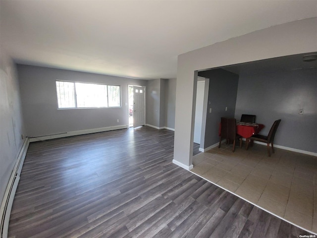 unfurnished room with dark hardwood / wood-style floors and a baseboard heating unit