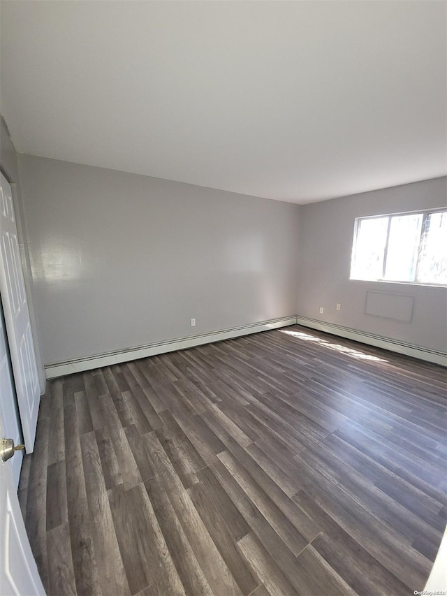 unfurnished room featuring dark hardwood / wood-style flooring and baseboard heating