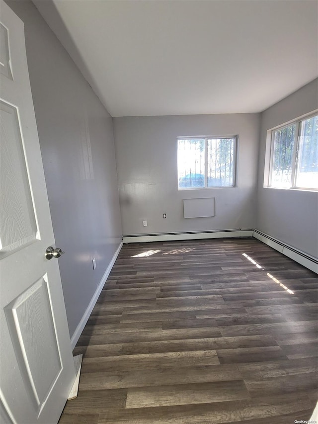 empty room with a wealth of natural light and dark wood-type flooring