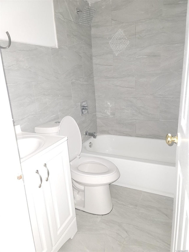 full bathroom featuring vanity, toilet, tile walls, and tiled shower / bath