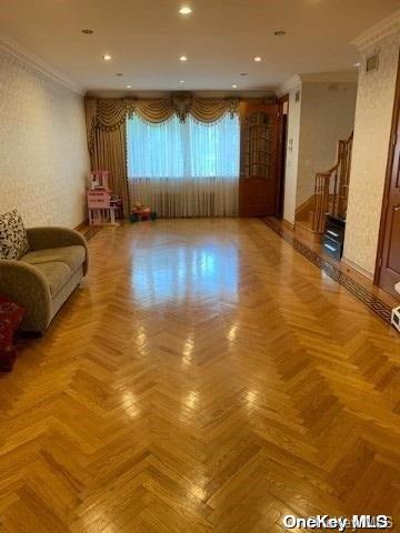 living room featuring crown molding and light parquet floors