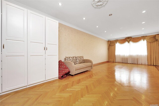 unfurnished room with light parquet floors and ornamental molding