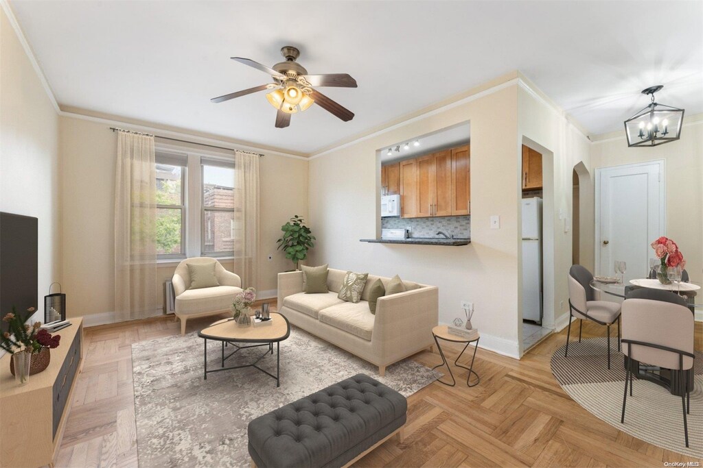 48-17 42nd St Unit 7B, Woodside, NY 11377 - living room with ceiling fan with notable chandelier, ornamental molding, and light parquet floors