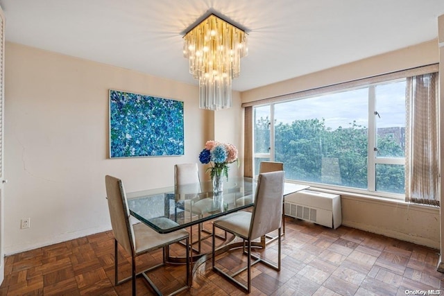 dining area with parquet floors, an inviting chandelier, and radiator