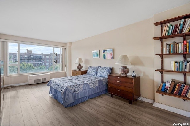 bedroom featuring hardwood / wood-style floors and radiator