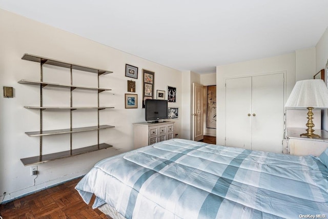 bedroom featuring dark parquet flooring and a closet