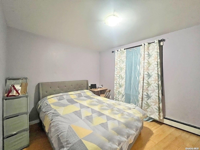 bedroom featuring hardwood / wood-style flooring and a baseboard radiator