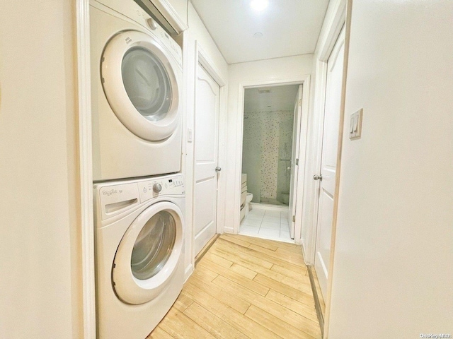 laundry area featuring stacked washer and dryer and light hardwood / wood-style floors