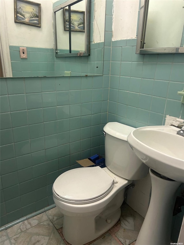 bathroom with tile walls and toilet