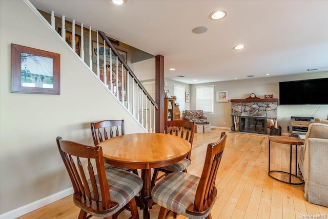 dining space featuring a fireplace and light hardwood / wood-style floors