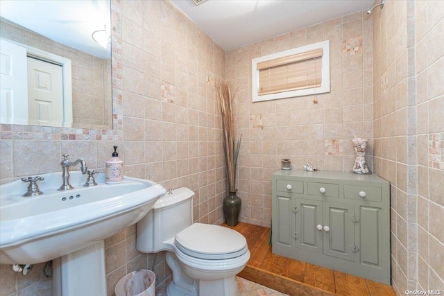 bathroom featuring tasteful backsplash, toilet, tile walls, and sink