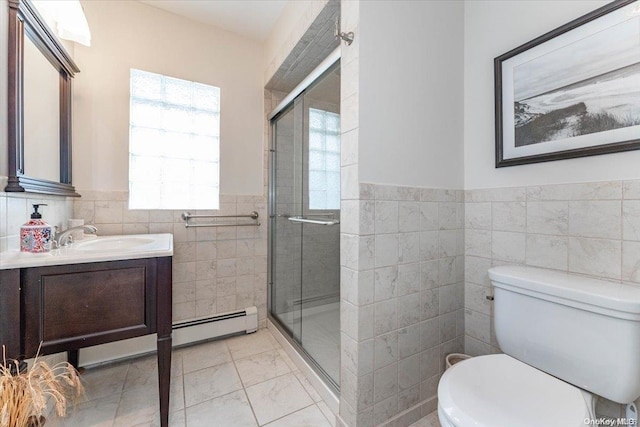 bathroom featuring vanity, toilet, baseboard heating, tile walls, and an enclosed shower