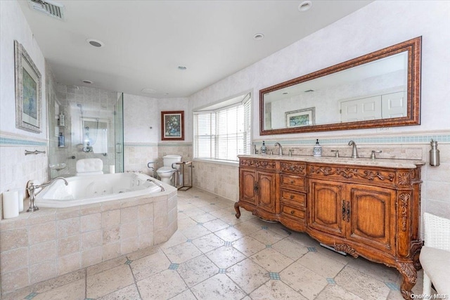 full bathroom with vanity, toilet, tile walls, and a bidet