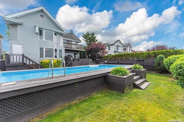 view of swimming pool featuring a yard and a deck