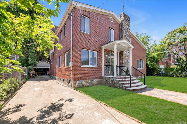 view of front of home with a front yard, an outbuilding, and a garage