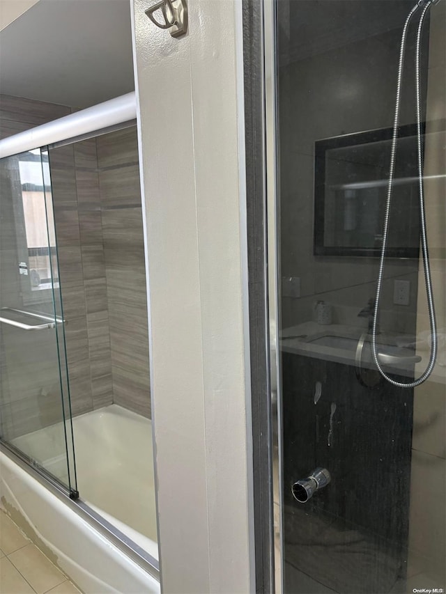 bathroom with tile patterned floors and bath / shower combo with glass door