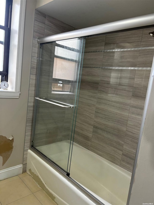 bathroom with tile patterned floors, plenty of natural light, and combined bath / shower with glass door