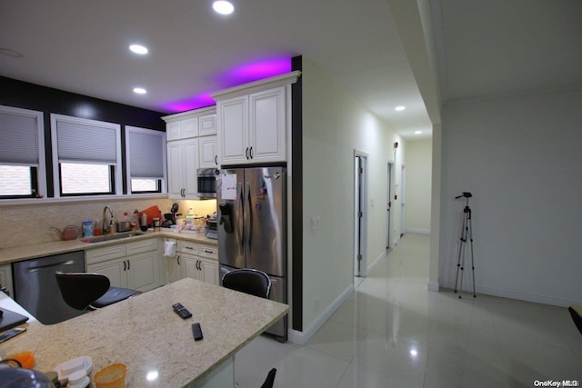 kitchen featuring white cabinets, sink, light tile patterned floors, light stone countertops, and appliances with stainless steel finishes