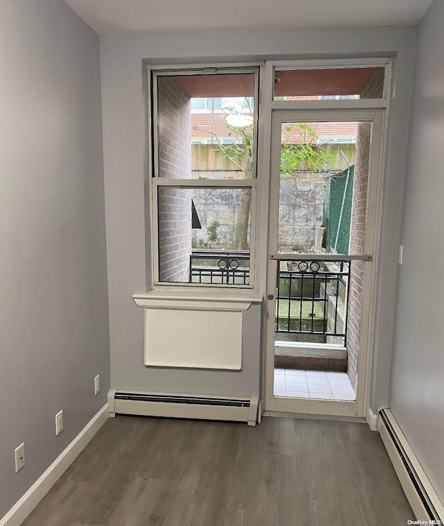 doorway with hardwood / wood-style flooring and baseboard heating