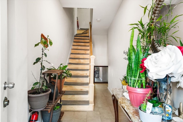 staircase featuring tile patterned flooring