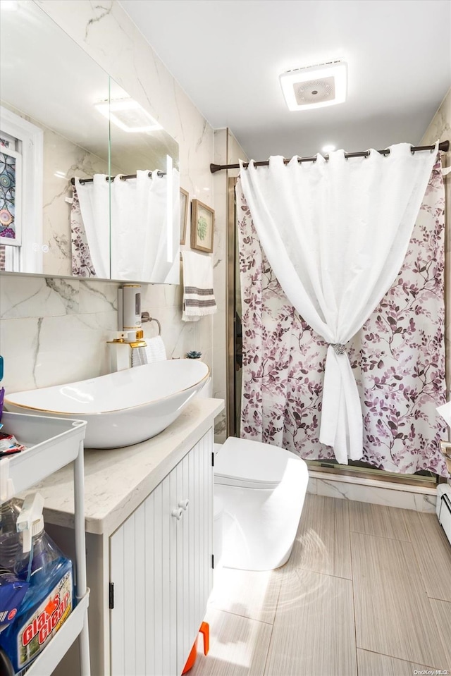 bathroom with a shower with curtain, vanity, toilet, and tile walls