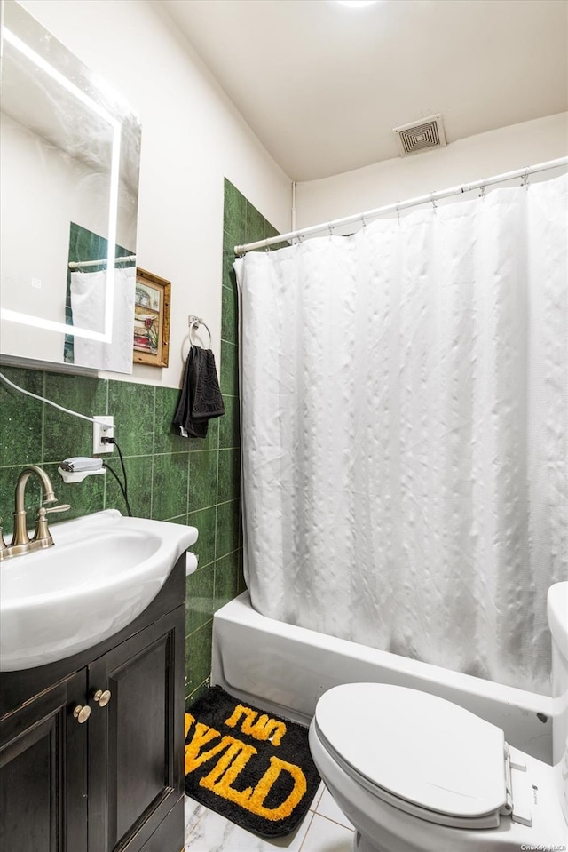 full bathroom with shower / bath combo, tile patterned floors, vanity, tile walls, and toilet