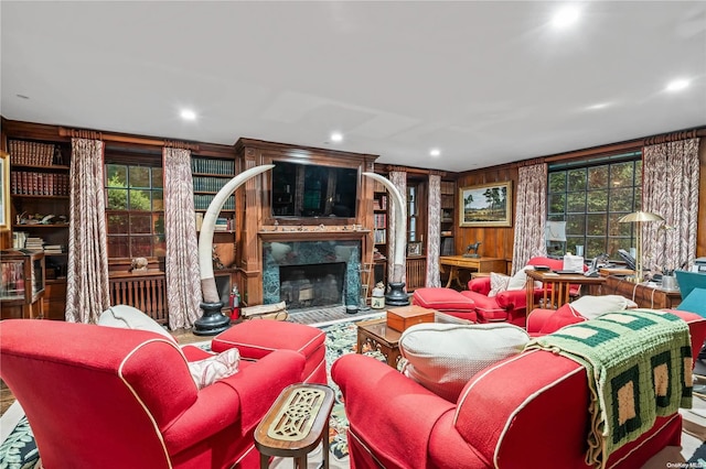 living room featuring wood walls and a premium fireplace