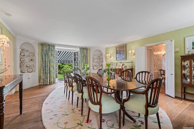 dining area with light hardwood / wood-style flooring, built in features, and ornamental molding