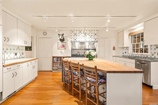 200 Cleft Rd, Mill Neck, NY 11765 - kitchen featuring stainless steel dishwasher, butcher block counters, tasteful backsplash, white cabinets, and a breakfast bar