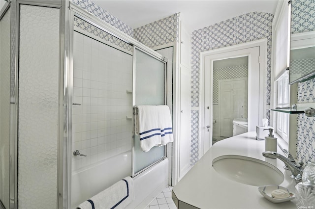 full bathroom featuring shower / bath combination with glass door, tile patterned flooring, vanity, and toilet