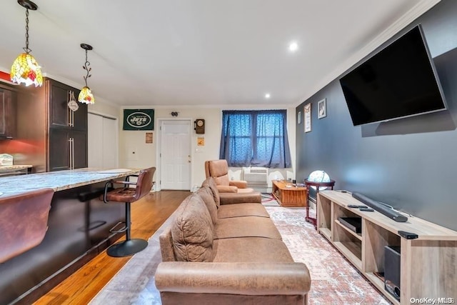 living room with ornamental molding and light hardwood / wood-style flooring