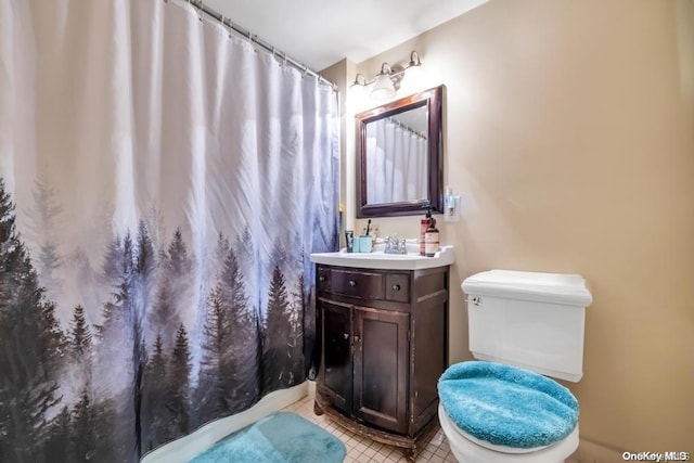 bathroom with tile patterned flooring, vanity, and toilet