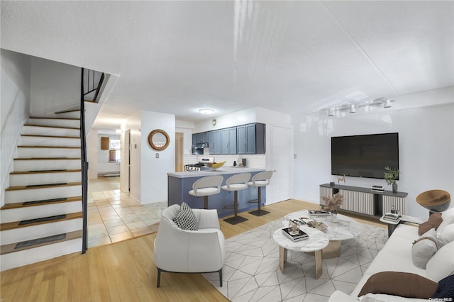 living room featuring light hardwood / wood-style flooring and a textured ceiling