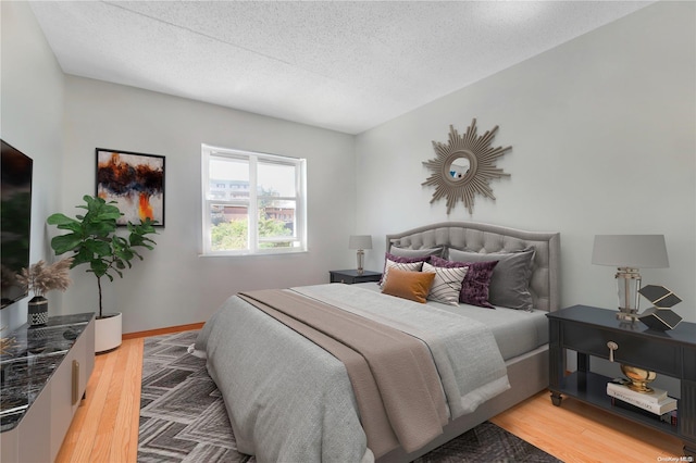 bedroom featuring a textured ceiling and light wood-type flooring