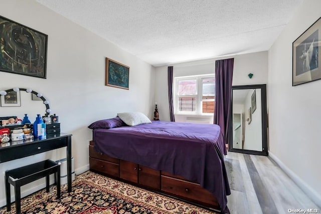 bedroom featuring hardwood / wood-style floors and a textured ceiling