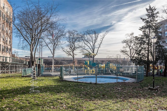 view of swimming pool featuring a playground and a yard