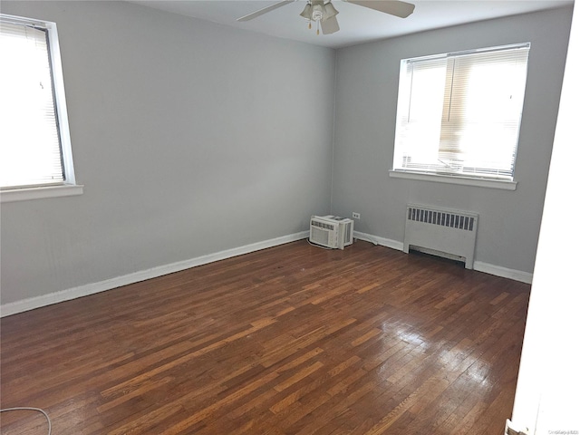 spare room featuring radiator, ceiling fan, and dark hardwood / wood-style floors