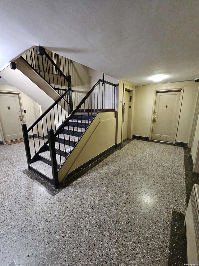 stairway featuring a textured ceiling